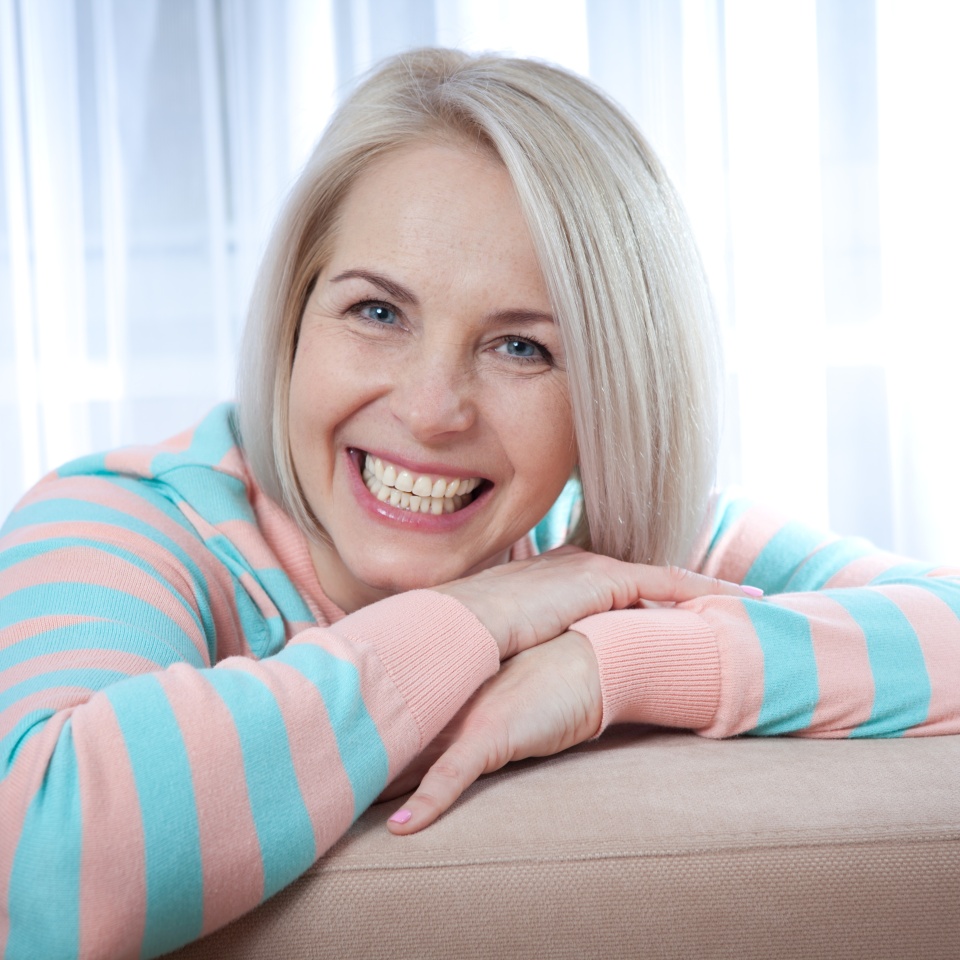 Close-up of a woman's smiling face relaxing at home