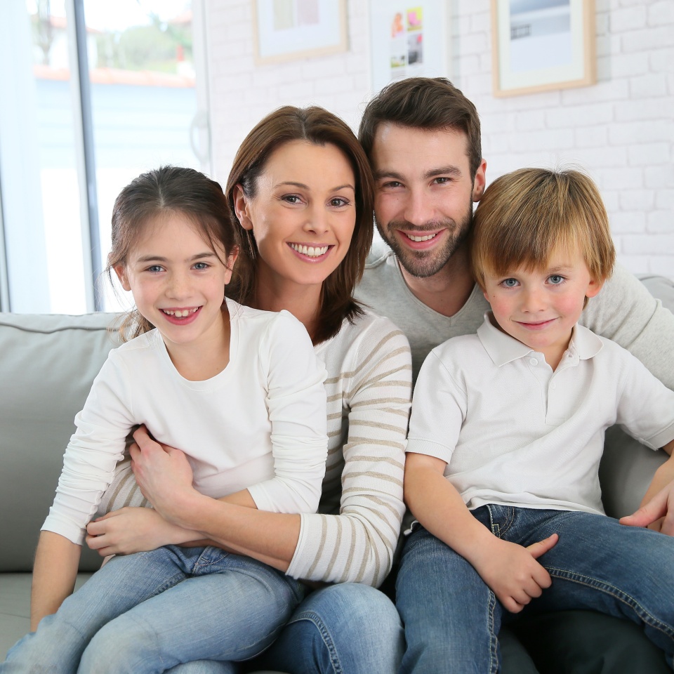 Cheerful family smiling together on a couch at home
