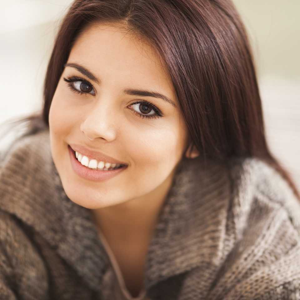 Close-up portrait of a young woman smiling at the camera