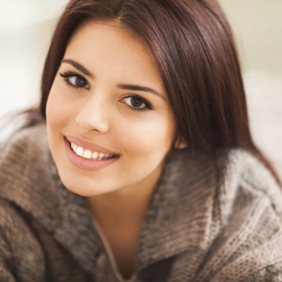 Close-up portrait of a young woman smiling at the camera