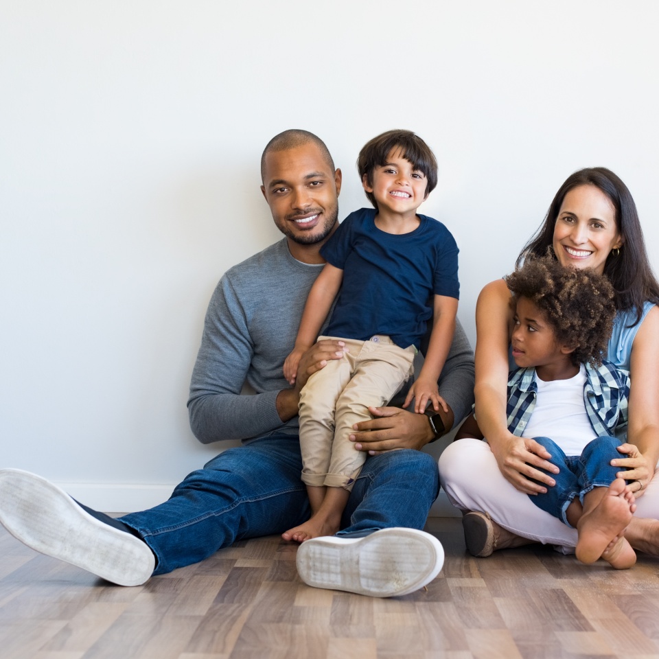 Smiling family with two children sitting together at home