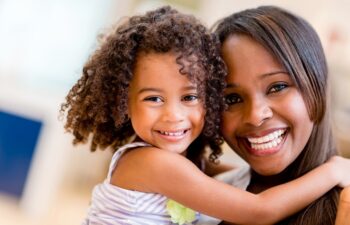 Smiling mother and daughter posing together