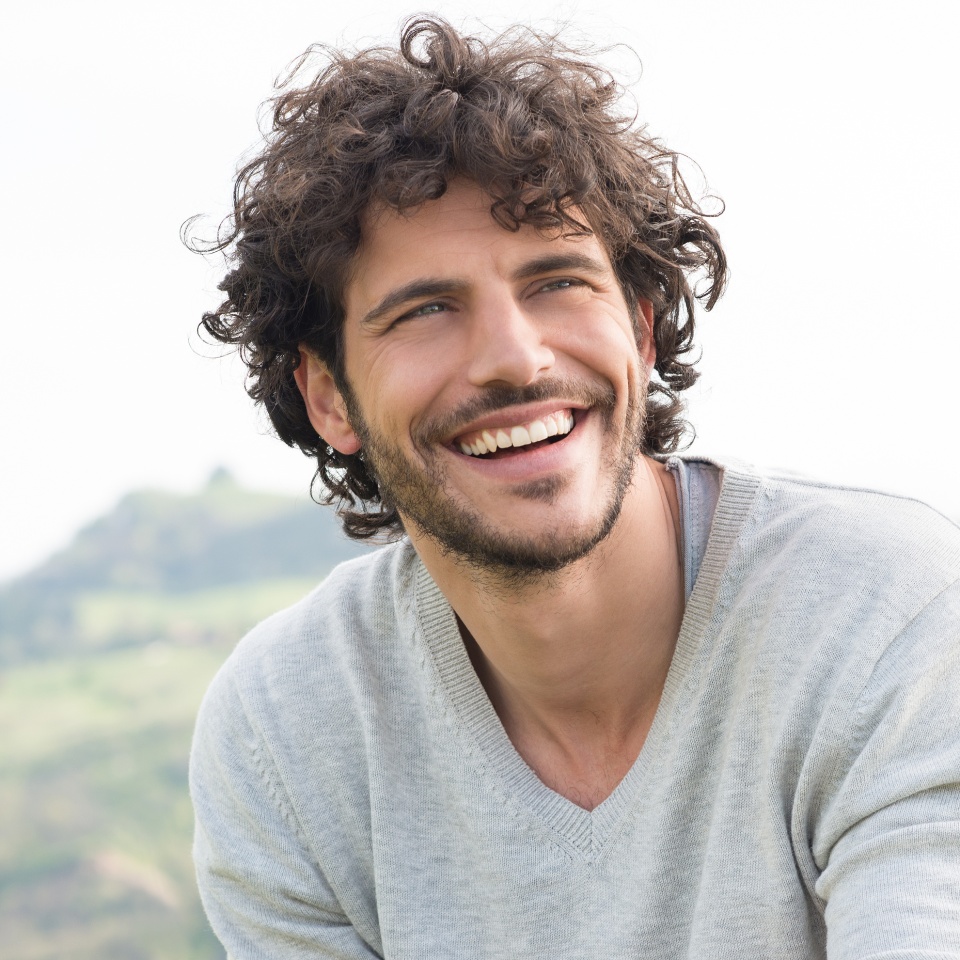 Smiling young man posing for a portrait outdoors