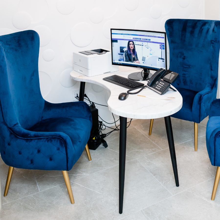 Small office area with round table, blue chairs, computer and printer