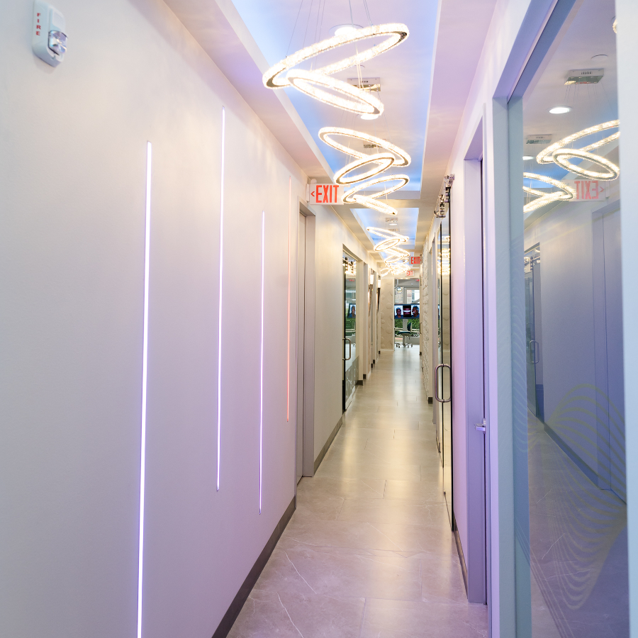 Modern hallway with LED wall lights and glass doors