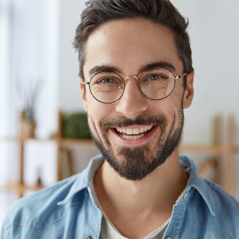 Smiling man with stubble wearing round glasses