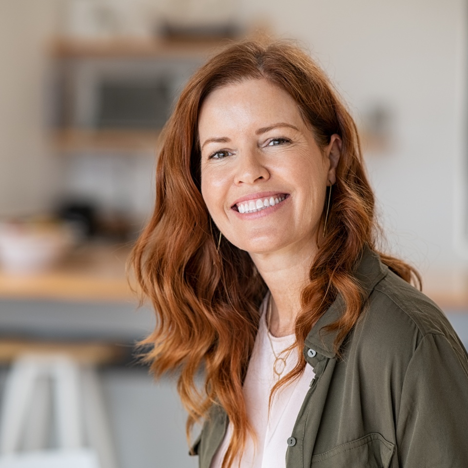 Smiling middle-aged woman with red hair showing a bright smile