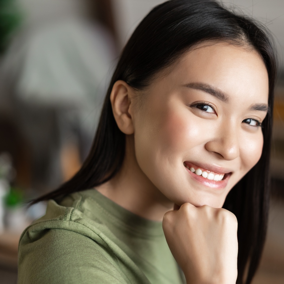 Young woman smiling at the camera while relaxing at home