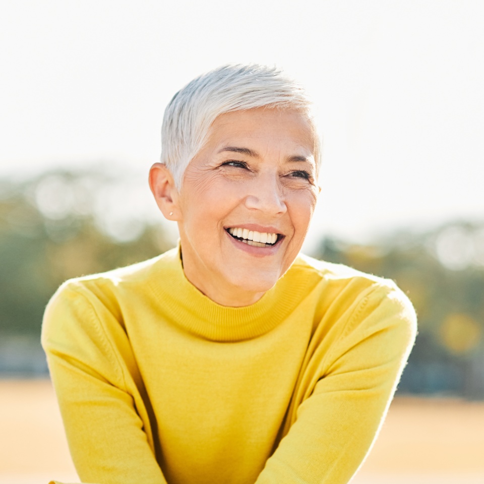 Happy senior woman smiling outdoors in a park