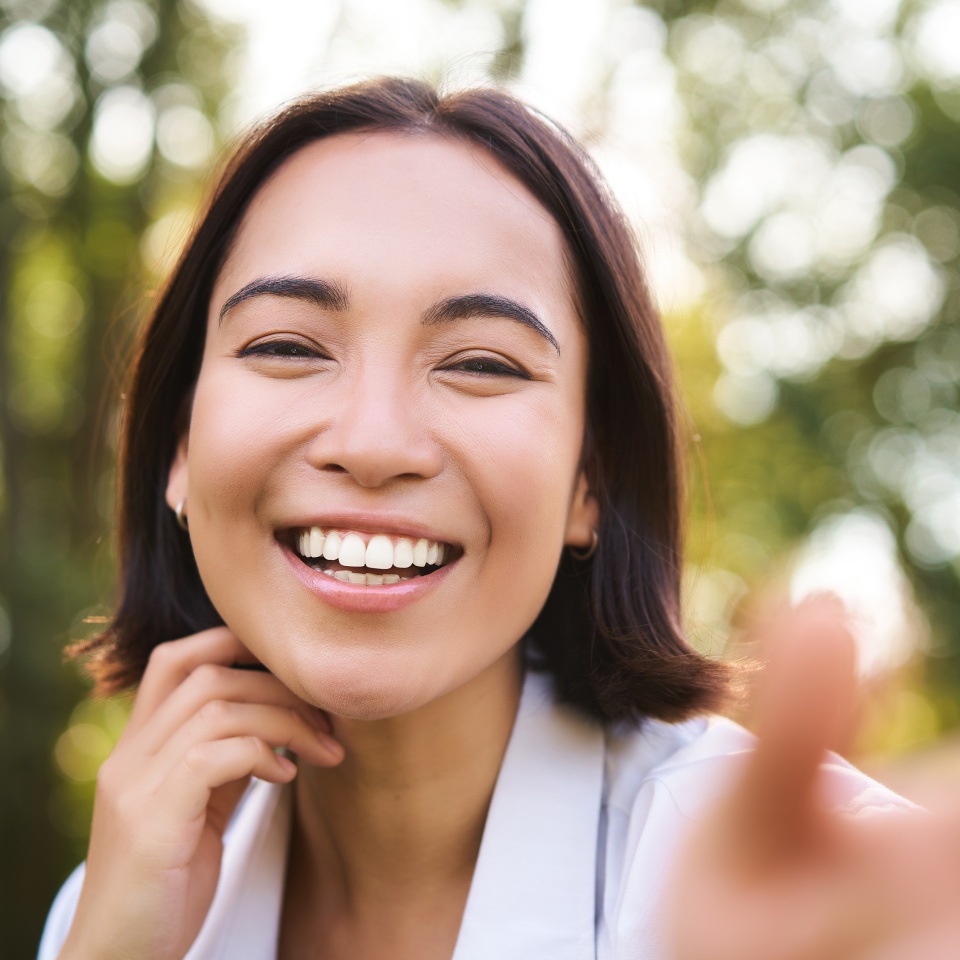 Smiling woman laughing while walking in a park