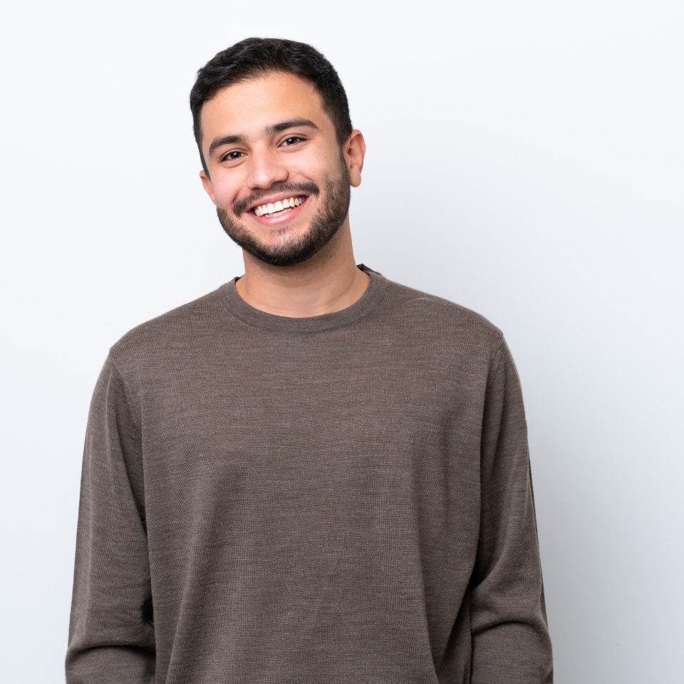 Young man laughing against a white background