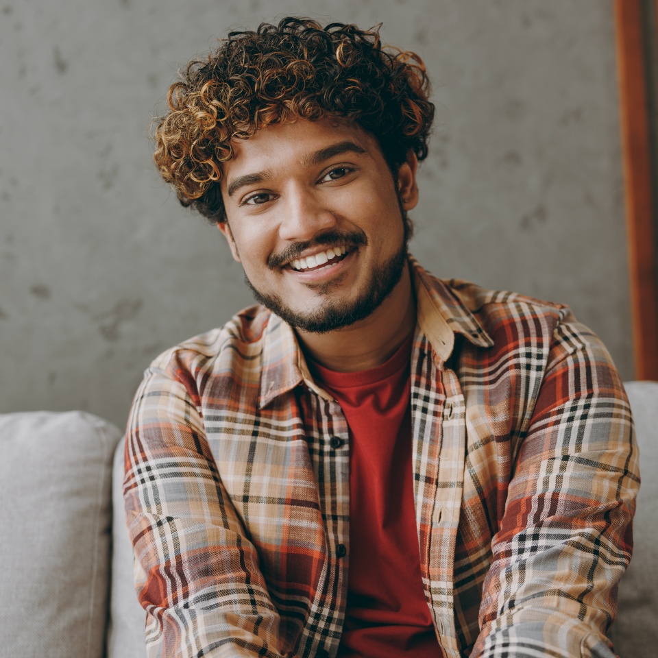 Smiling man relaxing on a couch at home