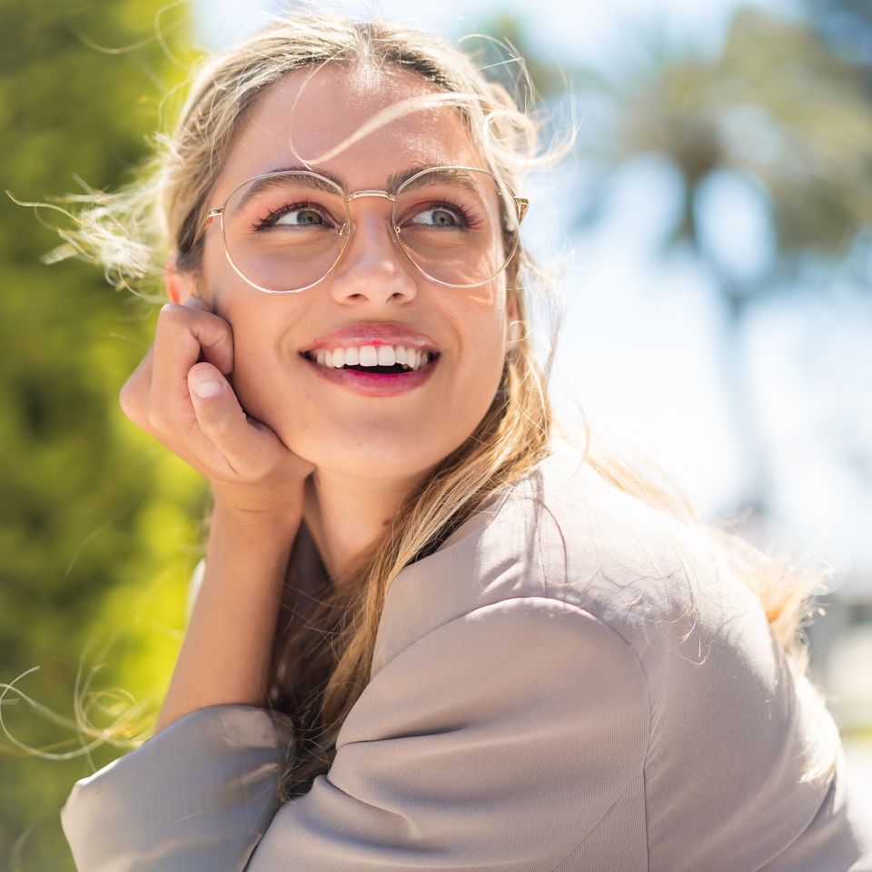 Woman with glasses smiling outdoors