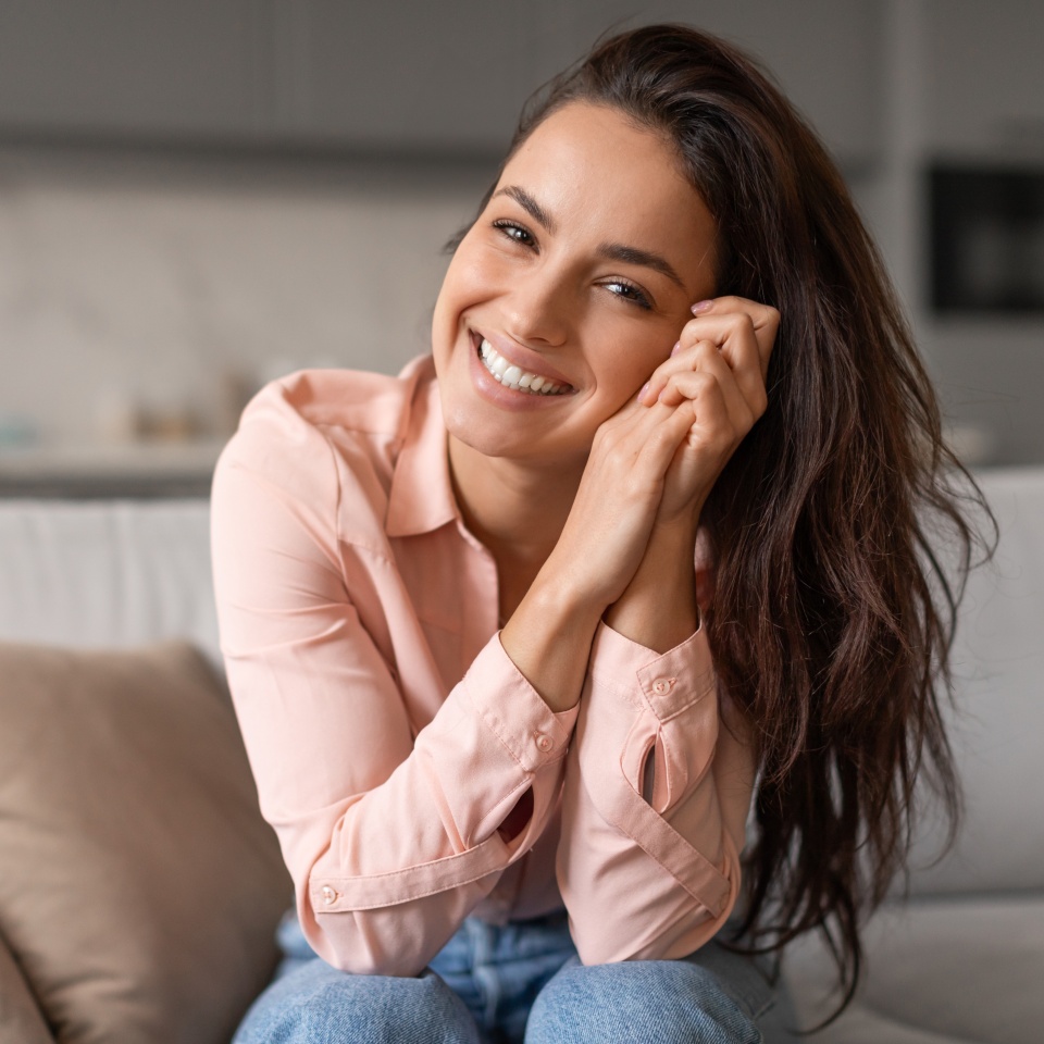 Smiling woman playfully cradling her face