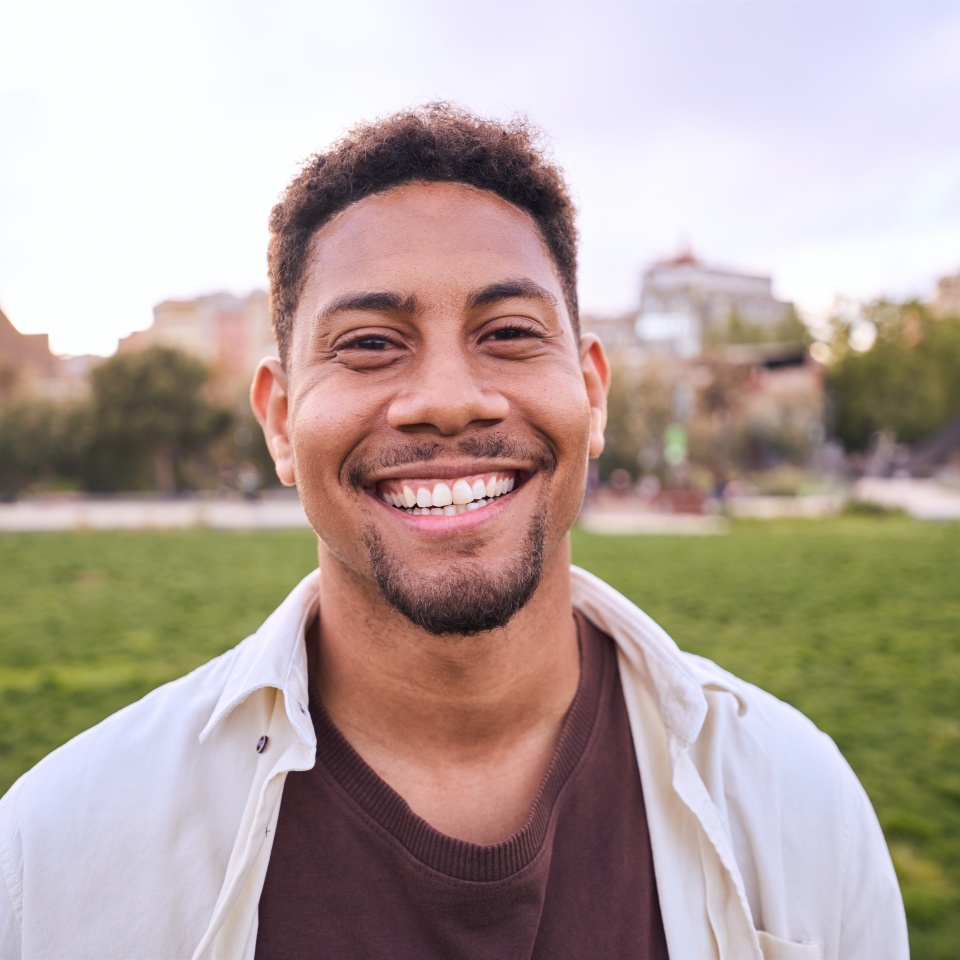 Cheerful bearded man smiling outdoors