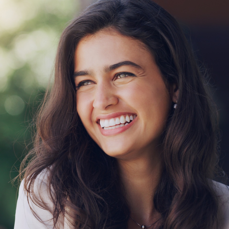 Smiling woman outdoors in nature enjoying a peaceful moment