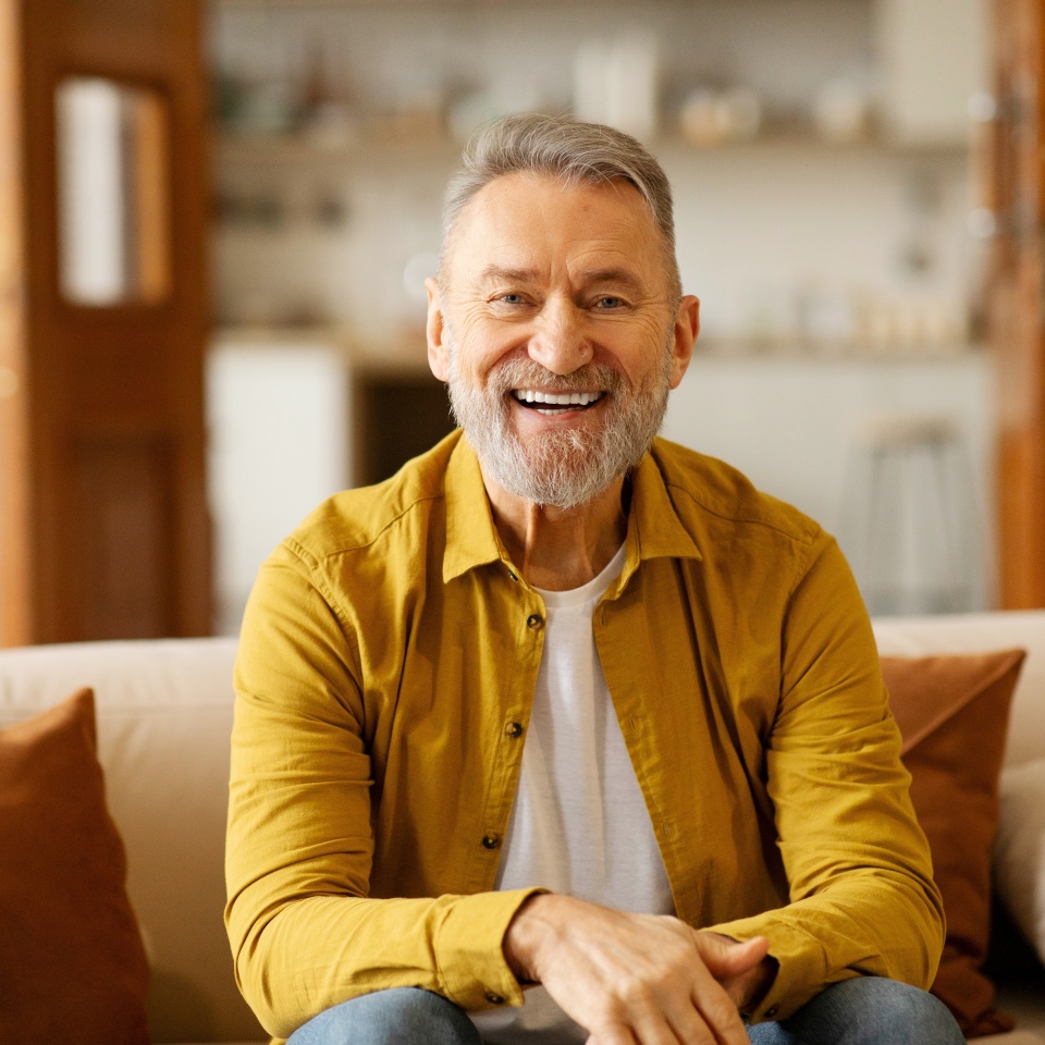 Happy older man laughing while looking at the camera