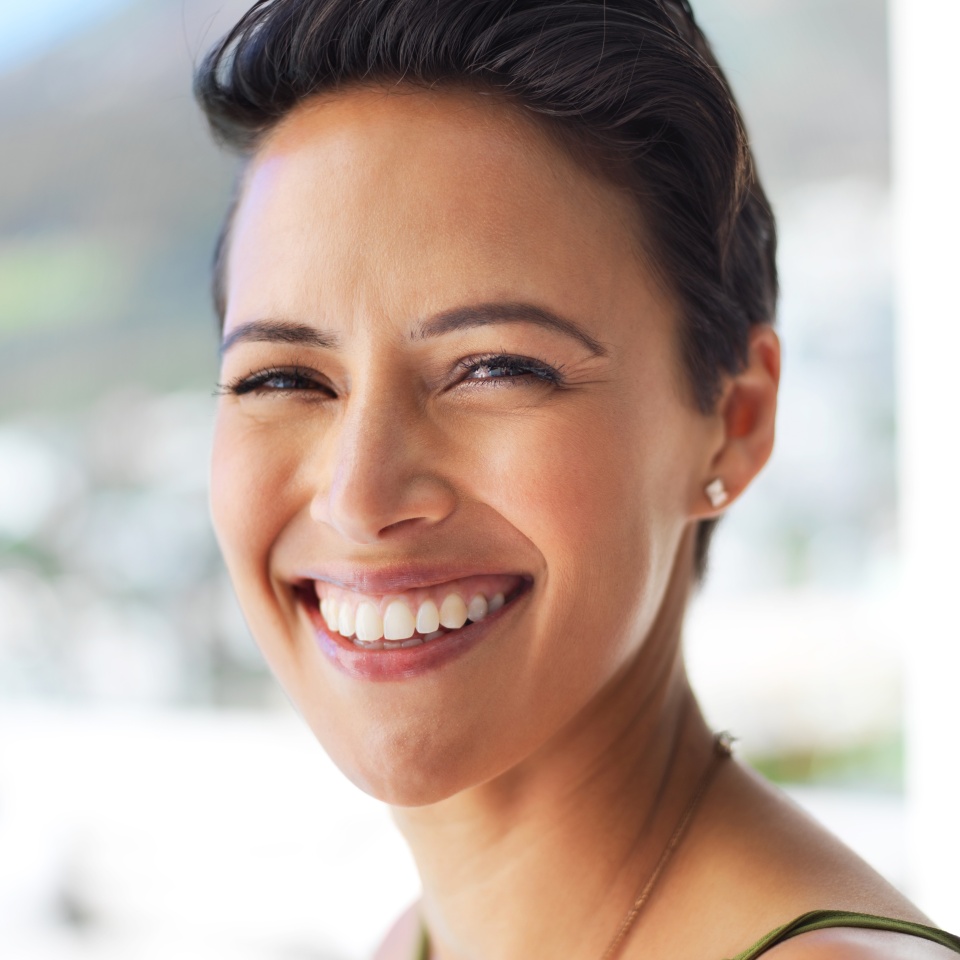 Smiling woman outdoors showing off her bright, healthy smile
