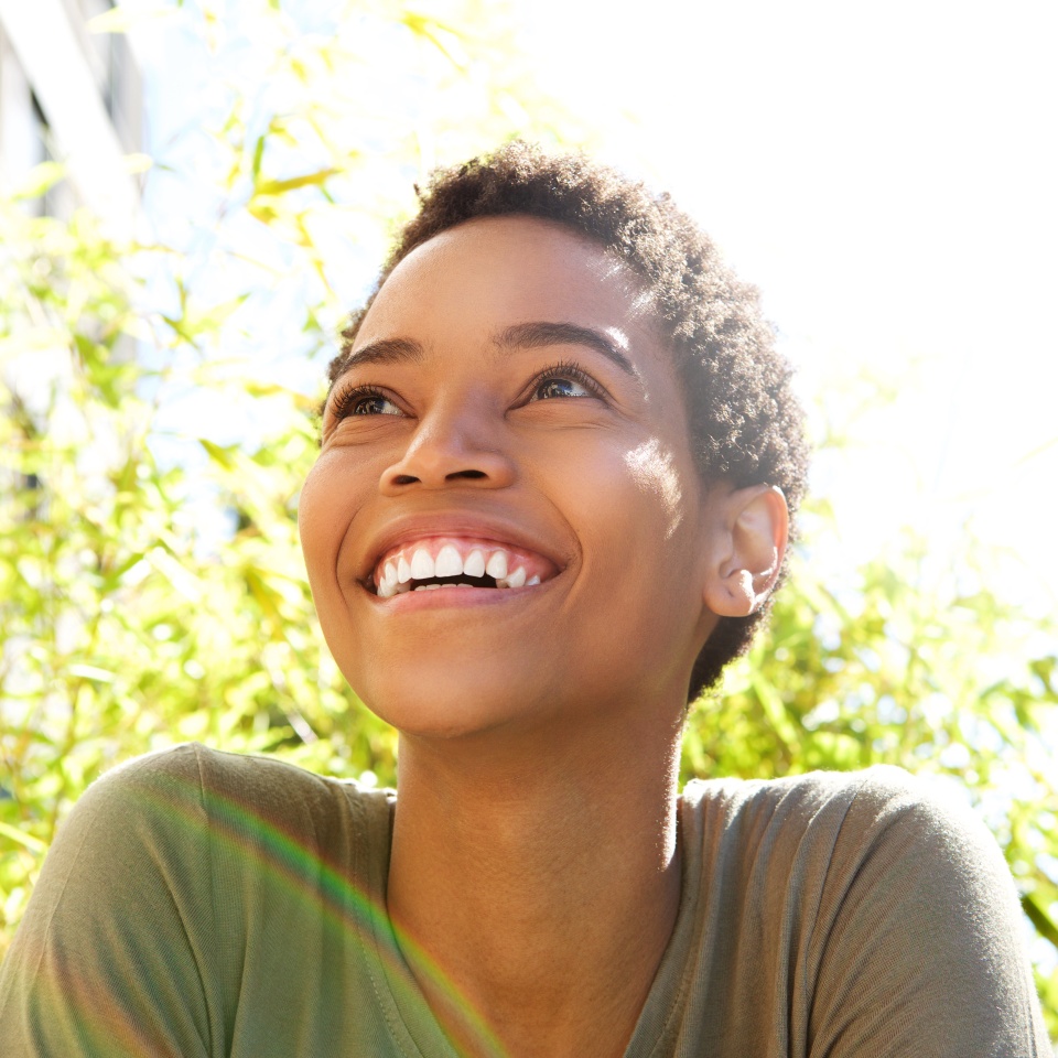 Close-up portrait of a young woman smiling outdoors