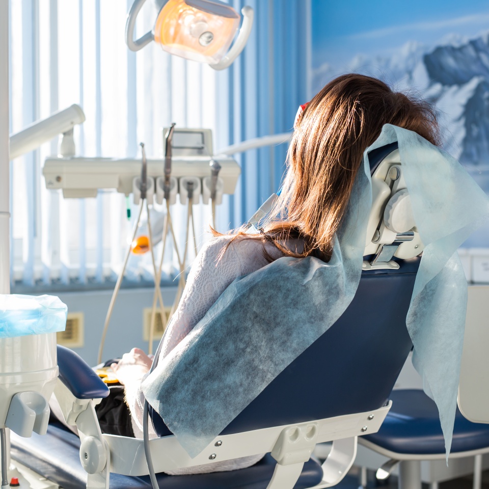 Patient sitting on dental chair, waiting for her dentist. Dental medicine, dental care, prevention, health concept.