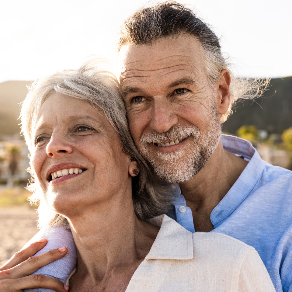 Beautiful happy senior couple dating at the seaside during summertime - Mature married couple in love bonding outdoors at the beach, concepts about elderly lifestyle, relationship and quality of life