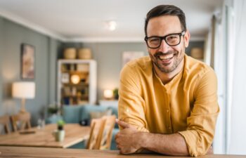 One man adult caucasian male with beard and eyeglasses stand at home happy smile copy space